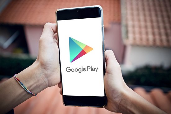 Ein Handy in einer Hand, mit Google Play Logo auf dem Bildschirm
