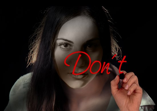 Frau malt mit Edding das Wort "Don´t" in das Bild